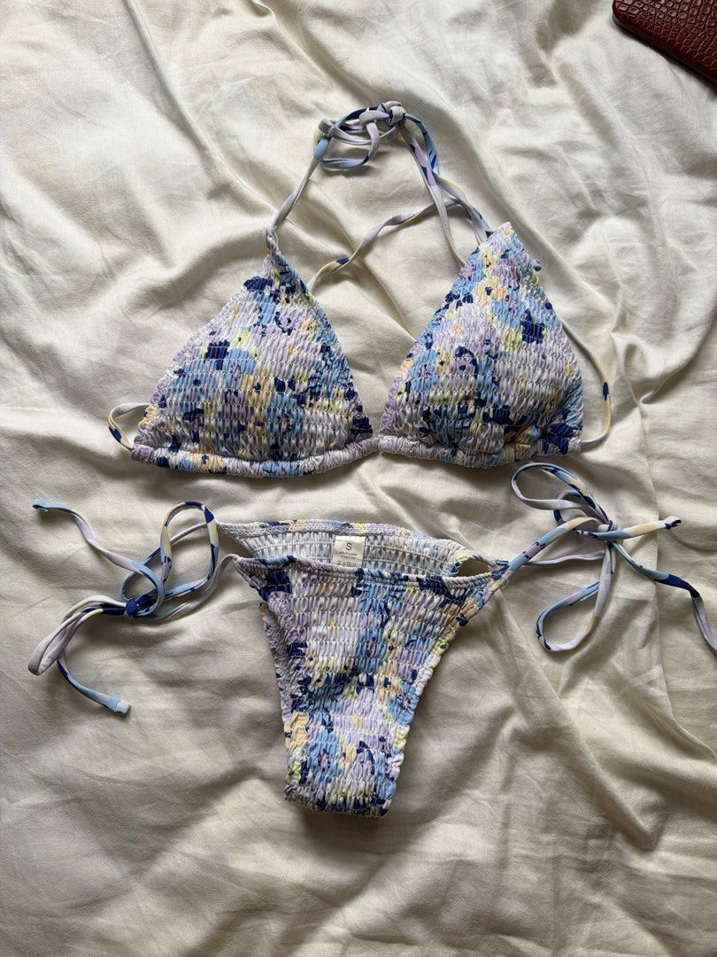 Blue Floral Smocked Bikini Set Size S (Category: Bikinis & Swimsuits) located in Quezon City. Submitted by stuffbyviel (Listing ID 1467180982, Image 1). Description: - Style: Blue and purple floral print bikini set - Size: Small - Details: Smocked fabric texture, halter triangle top with adjustable tie back, low-rise bottoms with side ties - Condition: Worn once for photos, freshly washed and clean - Perfect for: Beach days or pool parties.