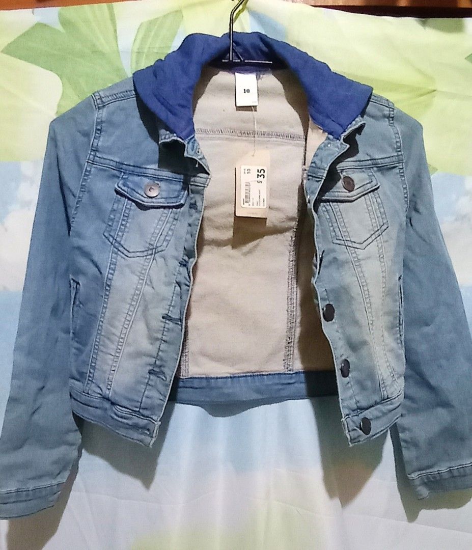 Blue Wash Hooded Denim Jacket Size 10 (Category: Babies & Kids Fashion) located in Mabalacat. Submitted by kencloset (Listing ID 1467262127, Image 1). Description: - Blue wash denim jacket with a blue hood. - Size 10. - Metal buttons down the front, on the chest pockets, and cuffs. - Two front hand pockets. Two chest pockets. - Unworn piece still attached with original store tag. - Clean inner lining..