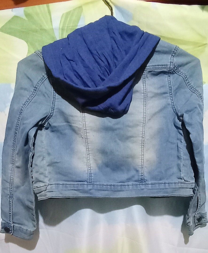 Blue Wash Hooded Denim Jacket Size 10 (Category: Babies & Kids Fashion) located in Mabalacat. Submitted by kencloset (Listing ID 1467262127, Image 2). Description: - Blue wash denim jacket with a blue hood. - Size 10. - Metal buttons down the front, on the chest pockets, and cuffs. - Two front hand pockets. Two chest pockets. - Unworn piece still attached with original store tag. - Clean inner lining..
