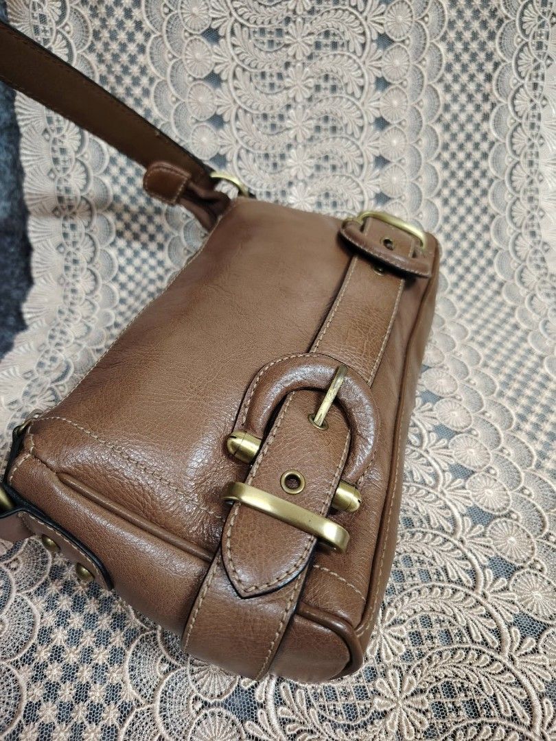 BROWN KILIBAG (Category: Shoulder Bags) located in Valenzuela. Submitted by anna.banana10 (Listing ID 1467286631, Image 3). Description: - Color & Material: Brown simulated leather finish - Closure: Secure top zipper to keep belongings safe - Strap: Comfortable single shoulder strap - Hardware: Stylish antiqued brass dual buckles on the front - Capacity: Compact size, ideal for daily essentials - Interior: Clean lining Medium in size.
