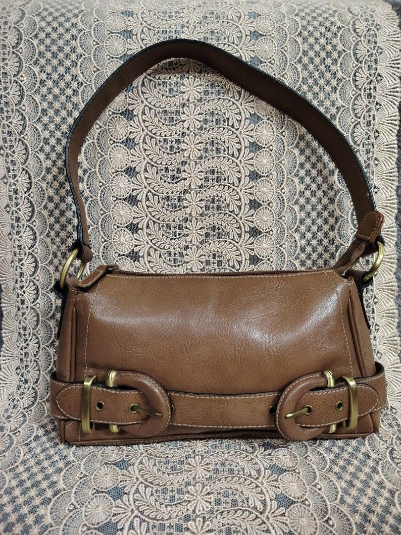 BROWN KILIBAG (Category: Shoulder Bags) located in Valenzuela. Submitted by anna.banana10 (Listing ID 1467286631, Image 1). Description: - Color & Material: Brown simulated leather finish - Closure: Secure top zipper to keep belongings safe - Strap: Comfortable single shoulder strap - Hardware: Stylish antiqued brass dual buckles on the front - Capacity: Compact size, ideal for daily essentials - Interior: Clean lining Medium in size.