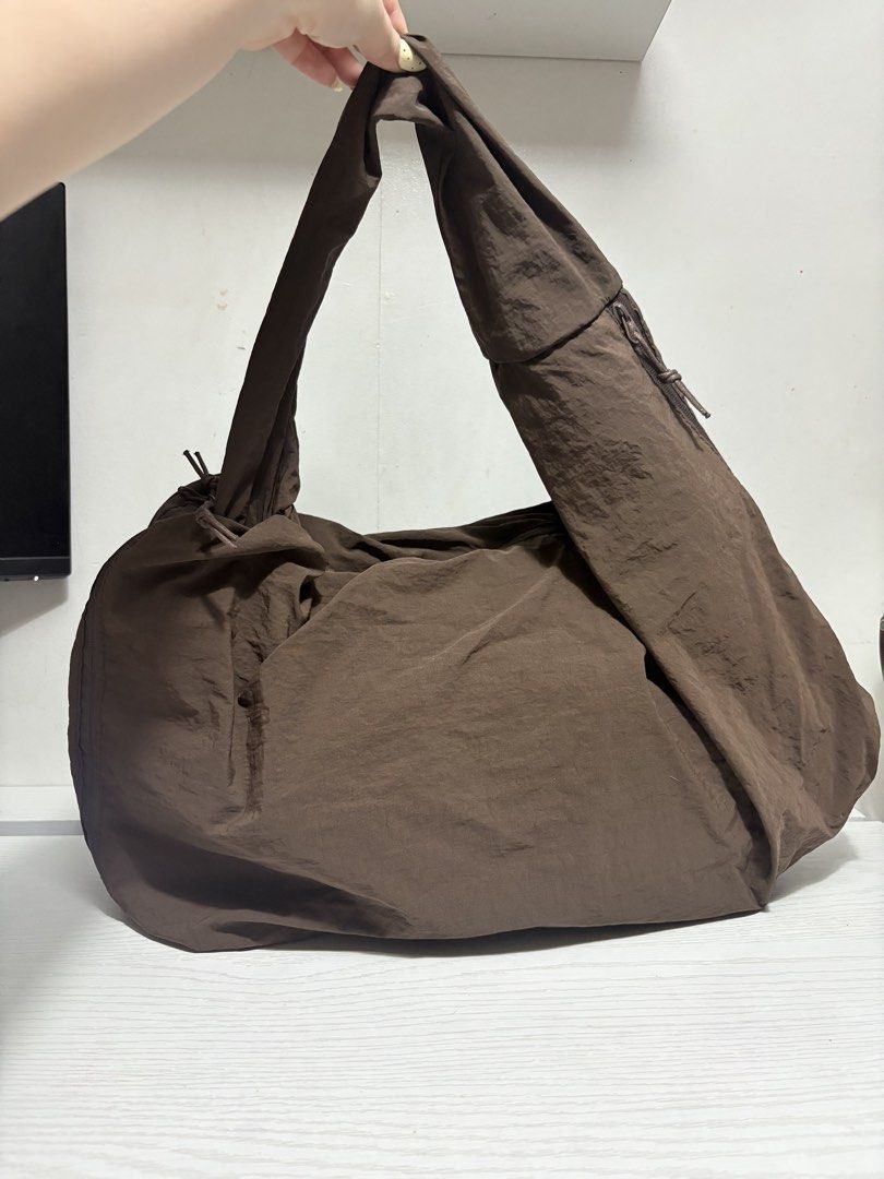 Brown Nylon Slouchy Shoulder Bag (Category: Shoulder Bags) located in Quezon City. Submitted by geminiselection (Listing ID 1467343572, Image 1). Description: 🎀 no brand, brandnew. Hindi pa nagagamit 🦋 super spacious and madami pockets, kasya 14 inches laptop. May lalagyan ng tumbler sa gilid 🩵 hobo bag, double lining. .