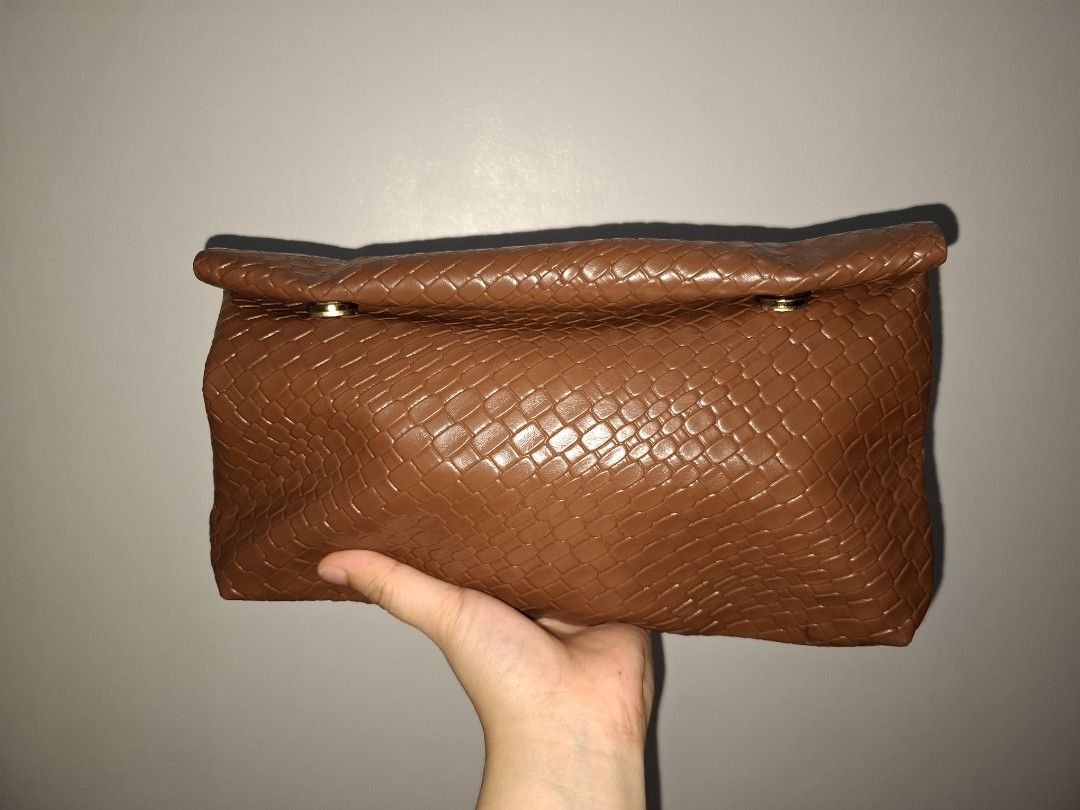 Brown Woven Clutch Bag (Category: Clutches) located in Binan City. Submitted by ataydeyes (Listing ID 1467356901, Image 3). Description: For sale: Brown Clutch 100 pesos only! 📌 Bought it from Tiktok Shop, di ko na rin po tanda orig price 📌 Never been used 📌 Super spacious 📌 Easy to carry 📌 Perfect for date nights or an everyday pouch! ❕️May onting black spot pero not super noticable naman. Pwede lalamove! Sagot po ni buyer ang delivery fee.