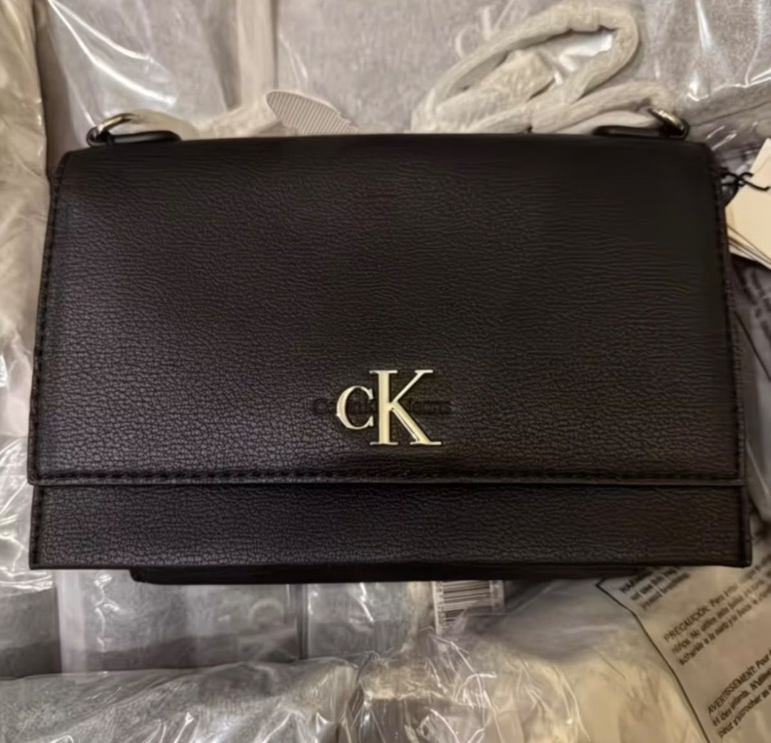 Calvin Klein Jeans Black Shoulder Bag (Category: Shoulder Bags) located in Pasay City. Submitted by kgemsluxuryboutique (Listing ID 1467339942, Image 1). Description: - Brand: Calvin Klein Jeans - Style: Crossbody bag - Color: Classic Black - Material/Texture: Structured pebbled finish - Hardware: Silver-tone with prominent front CK logo - Strap: Stylish metal chain links - Condition: Brand new with tags attached, includes original dust bag PLEAS