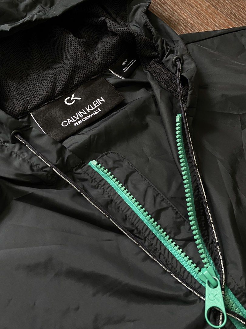 Calvin Klein Performance hooded windbreaker (Category: Coats, Jackets and Outerwear) located in Cebu City. Submitted by 0pong (Listing ID 1467201541, Image 3). Description: - Brand: Calvin Klein Performance - Item: Hooded windbreaker jacket - Color: Black with vibrant green front zipper and striped sleeve cuffs - Features: Adjustable hood, dual front pockets, and Calvin Klein Performance logo patch on front - Condition: As new - No issue - Size L