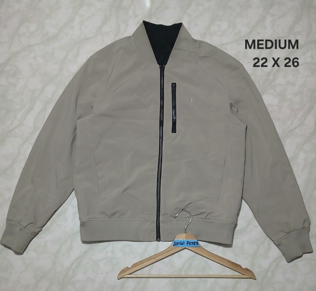 Calvin Klein Reversible Bomber Jacket Medium (Category: Coats, Jackets and Outerwear) located in Plaridel. Submitted by igieperez147282 (Listing ID 1467304692, Image 1). Description: - Brand: Calvin Klein - Style: Reversible bomber jacket - Size: Medium (Measures 22" x 26") - Colorway: Beige on one side, Black on the other - Details: Large CK logo printed on the black side, chest zipper pocket - Condition: Great outerwear piece for cooler weather