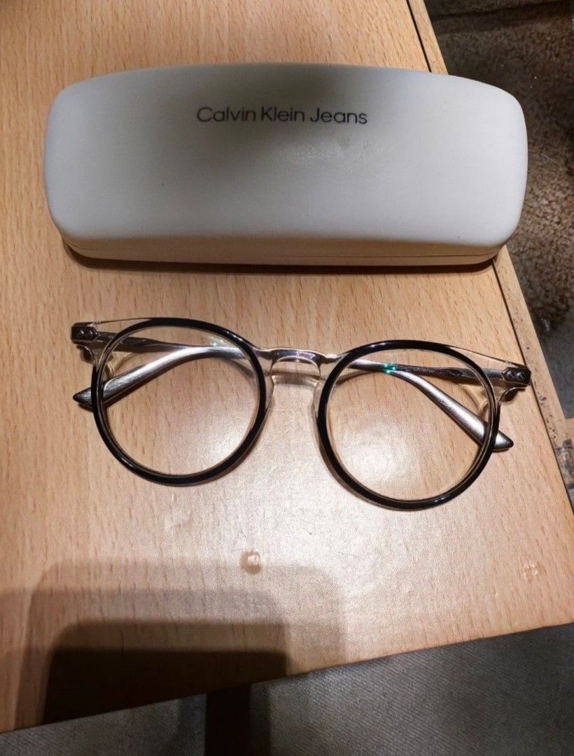 Calvin Klein Titanium CK18705 Eyeglass Frames (Category: Sunglasses & Eyewear) located in Cavite. Submitted by klosetnijuan (Listing ID 1467257485, Image 1). Description: Titanium frames from Calvin Klein, model CK18705. Black and clear front rims with silver temples. Measurements stamped on arm: 49-19-140. Includes original white Calvin Klein Jeans hard case and a free Vision Express voucher card - lense grade up to 300..