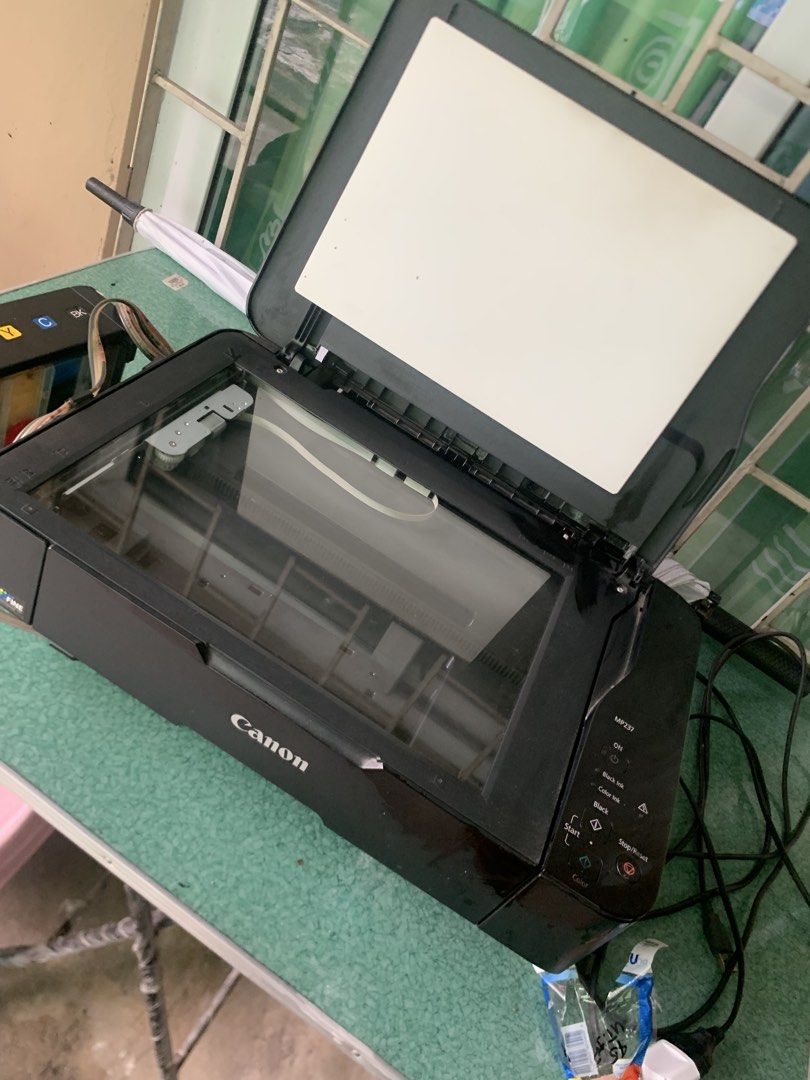 Canon PIXMA MP237 Printer with Ink Tank (Category: Printers, Scanners & Copiers) located in Mandaluyong City. Submitted by quickmountain.780662 (Listing ID 1467260794, Image 3). Description: - Model: Canon PIXMA MP237 All-in-One Printer - Functions: Print, copy, and scan with a built-in flatbed scanner - Ink System: Equipped with an external CISS ink tank for heavy-duty, low-cost printing - Inclusions: Complete set of refill bottles (Black, Cyan,