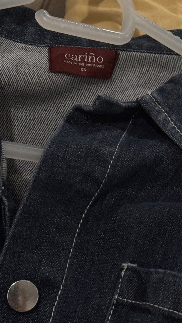 Cariño Denim Jacket XS (Category: Coats, Jackets and Outerwear) located in Quezon City. Submitted by lovedbymca (Listing ID 1467246721, Image 3). Description: - Brand: Cariño - Size: XS - Color: Dark wash denim with contrast white stitching - Details: Chest pockets, silver-tone buttons, collared neckline, long sleeves - Retail Price: 3,950 PHP.