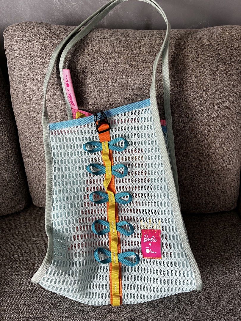 Carry Om (Category: Tote Bags) located in Las Pinas. Submitted by elai18 (Listing ID 1467234475, Image 1). Description: - Authentic Barbie branding tags - Light blue mesh tote bag with a bright, colorful mix of materials - Orange center strap featuring playful blue bow accents and a buckle closure - Pink inner compartment equipped with a handy zipper pocket - Comfortable double shoulder straps in pale green Medium size Rfs: Too small for me Retai
