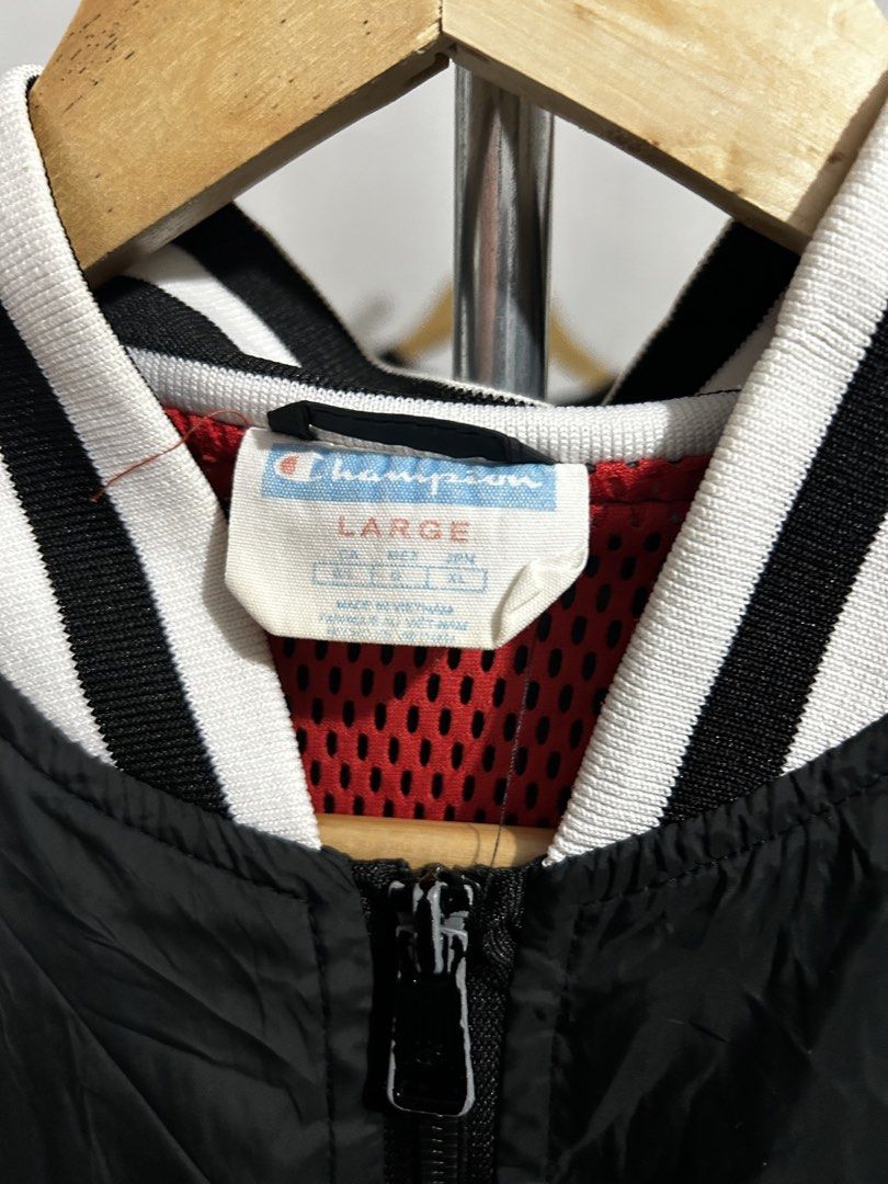 Champion Black Varsity Bomber Jacket Large (Category: Coats, Jackets and Outerwear) located in Manila. Submitted by livedog-d301 (Listing ID 1467311824, Image 3). Description: - Brand: Champion - Style: Varsity jacket with full zip closure - Color: Black with bold white embroidered logos (chest and back) - Size: Large - Details: Striped rib-knit collar, cuffs, and hem, with red mesh interior lining - Origin: Made in Vietnam - Condition: Ready to 