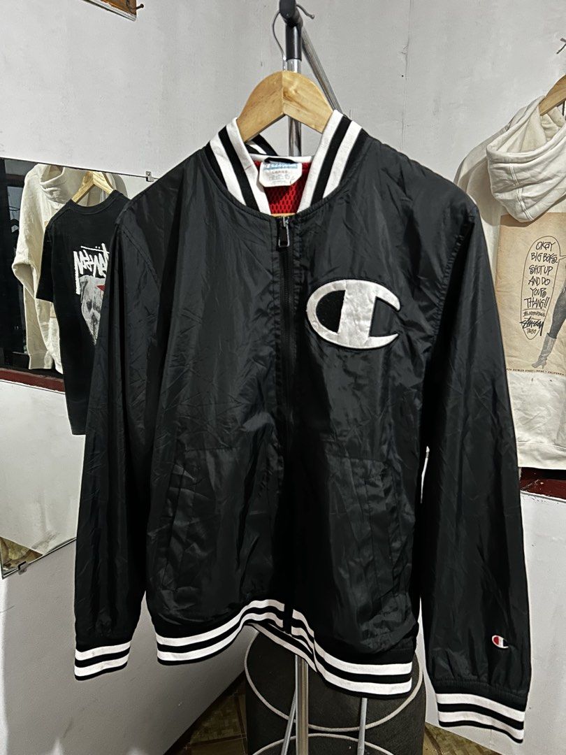 Champion Black Varsity Bomber Jacket Large (Category: Coats, Jackets and Outerwear) located in Manila. Submitted by livedog-d301 (Listing ID 1467311824, Image 1). Description: - Brand: Champion - Style: Varsity jacket with full zip closure - Color: Black with bold white embroidered logos (chest and back) - Size: Large - Details: Striped rib-knit collar, cuffs, and hem, with red mesh interior lining - Origin: Made in Vietnam - Condition: Ready to 
