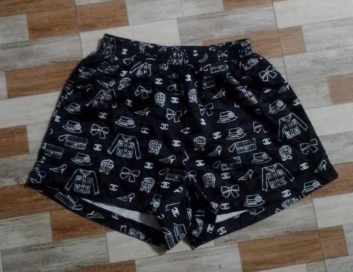 Chanel Black White Pattern Print Shorts (Category: Shorts) located in Manila. Submitted by jaythrifttt (Listing ID 1467289202, Image 1). Description: - Style: Relaxed fit lightweight black shorts - Design: White pattern print featuring Chanel iconography (jackets, bags, shoes, camellias, and CC logos) - Waistband: Comfortable elastic waistband - Details: Includes inner brand tag and clear, high-quality print - Condition: Clean surface and excelle