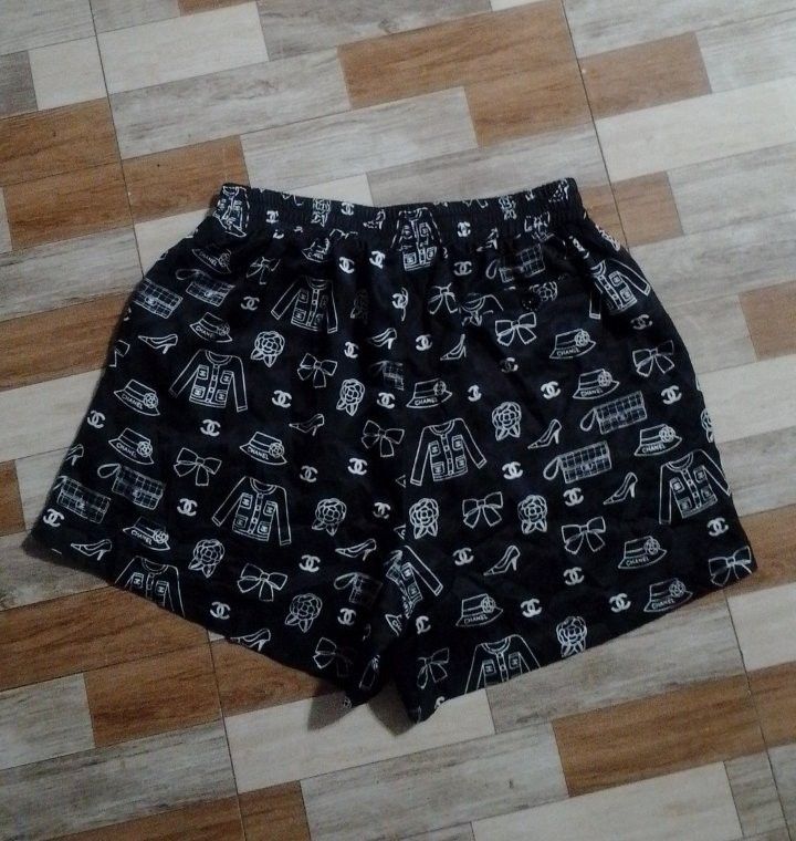 Chanel Black White Pattern Print Shorts (Category: Shorts) located in Manila. Submitted by jaythrifttt (Listing ID 1467289202, Image 2). Description: - Style: Relaxed fit lightweight black shorts - Design: White pattern print featuring Chanel iconography (jackets, bags, shoes, camellias, and CC logos) - Waistband: Comfortable elastic waistband - Details: Includes inner brand tag and clear, high-quality print - Condition: Clean surface and excelle
