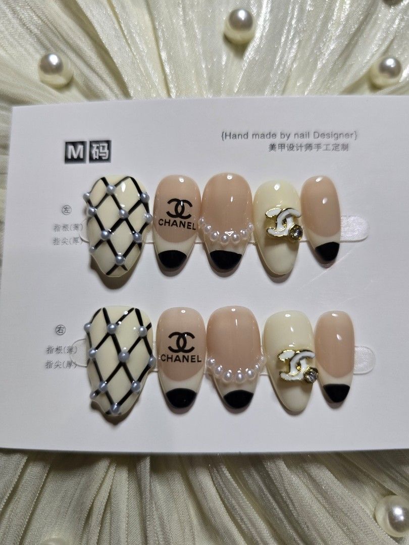 Chanel Inspired Press On Nails Size M Short Almond (Category: Hands & Nails) located in Makati City. Submitted by jangmiscloset (Listing ID 1467313608, Image 1). Description: - Handmade press-on nail set in Size M - Design: Classic beige & black French tips, pearl accents, quilted tweed pattern, and interlocking CC logos - Condition: Brand new, unused, and still on original display card - Includes complete application kit: nail file, wooden cutic