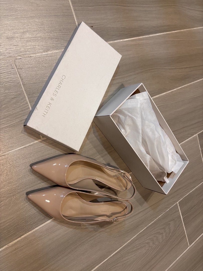 Charles & Keith Beige Slingback Pumps (Category: Heels) located in San Pedro. Submitted by lala_leila (Listing ID 1467329813, Image 2). Description: - Brand: Charles & Keith - Size: 41 / 27cm - Style: Nude patent leather slingback pumps with low block heel - Details: Pointed toe, adjustable buckle strap, clean insoles, and glossy uppers - Condition: Great, includes original white branded shoebox - Versatility: Perfect neutral color that matches v