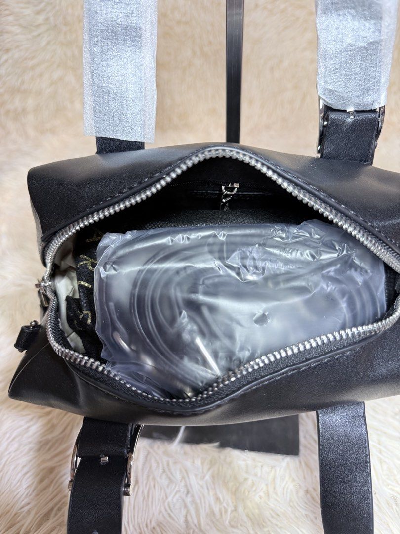 Charles & Keith Black Satchel Handbag (Category: Luxury Bags & Wallets) located in Caloocan City. Submitted by hirahira.co (Listing ID 1467282422, Image 2). Description: - Brand: Charles & Keith - Material: Premium black leather-look finish - Condition: Brand new with protective wrapping on handles - Hardware: Silver-tone with secure zipper closure - Details: Vertical side buckle accent and side D-ring for strap attachment - Style: Structured, ne