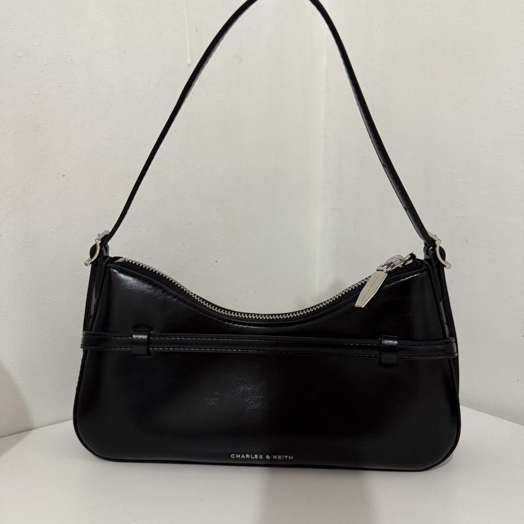 Charles & Keith Black Shoulder Bag (Category: Shoulder Bags) located in Quezon City. Submitted by 0ffTheRack (Listing ID 1467213404, Image 2). Description: - Style: Shoulder Bag (CK2-20671702) - Silver hardware - Can we worn as a shoulder bag or a crossbody bag - Brand new with product tags and clean interior/exterior - Inclusions: Comes with original dust bag and crossbody extension.