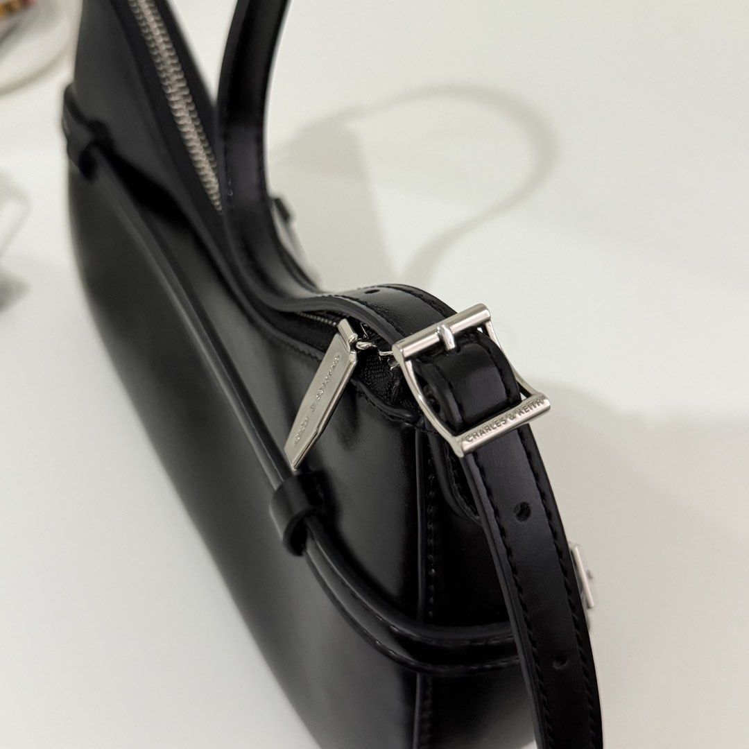 Charles & Keith Black Shoulder Bag (Category: Shoulder Bags) located in Quezon City. Submitted by 0ffTheRack (Listing ID 1467213404, Image 3). Description: - Style: Shoulder Bag (CK2-20671702) - Silver hardware - Can we worn as a shoulder bag or a crossbody bag - Brand new with product tags and clean interior/exterior - Inclusions: Comes with original dust bag and crossbody extension.