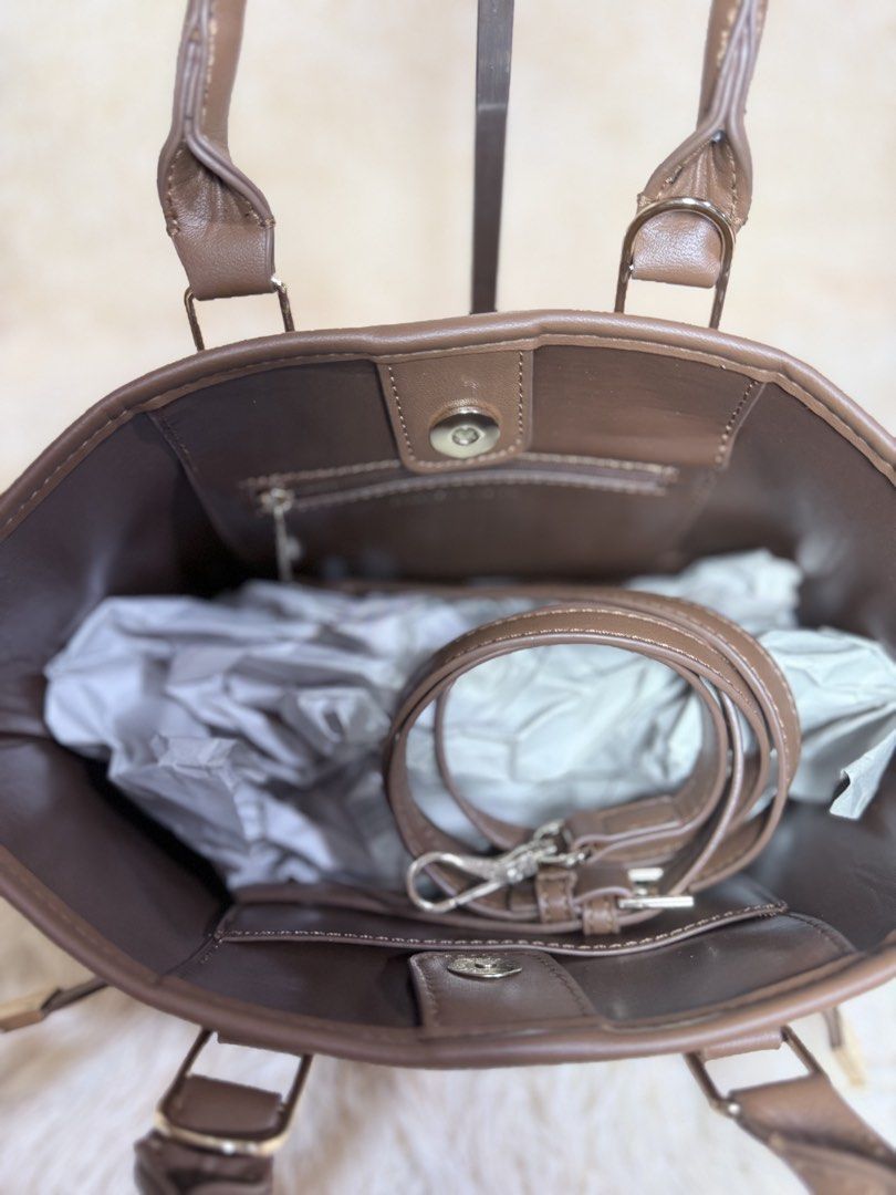 Charles & Keith Brown Handbag with Padlock (Category: Luxury Bags & Wallets) located in Caloocan City. Submitted by hirahira.co (Listing ID 1467284205, Image 3). Description: - Brand: Charles & Keith - Material: Brown faux leather - Hardware: Gold-tone - Features: Dual top handles, decorative front padlock, structured shape with flat base and protective metal feet - Condition: Clean interior and exterior - Style: Versatile neutral shade, perfect 