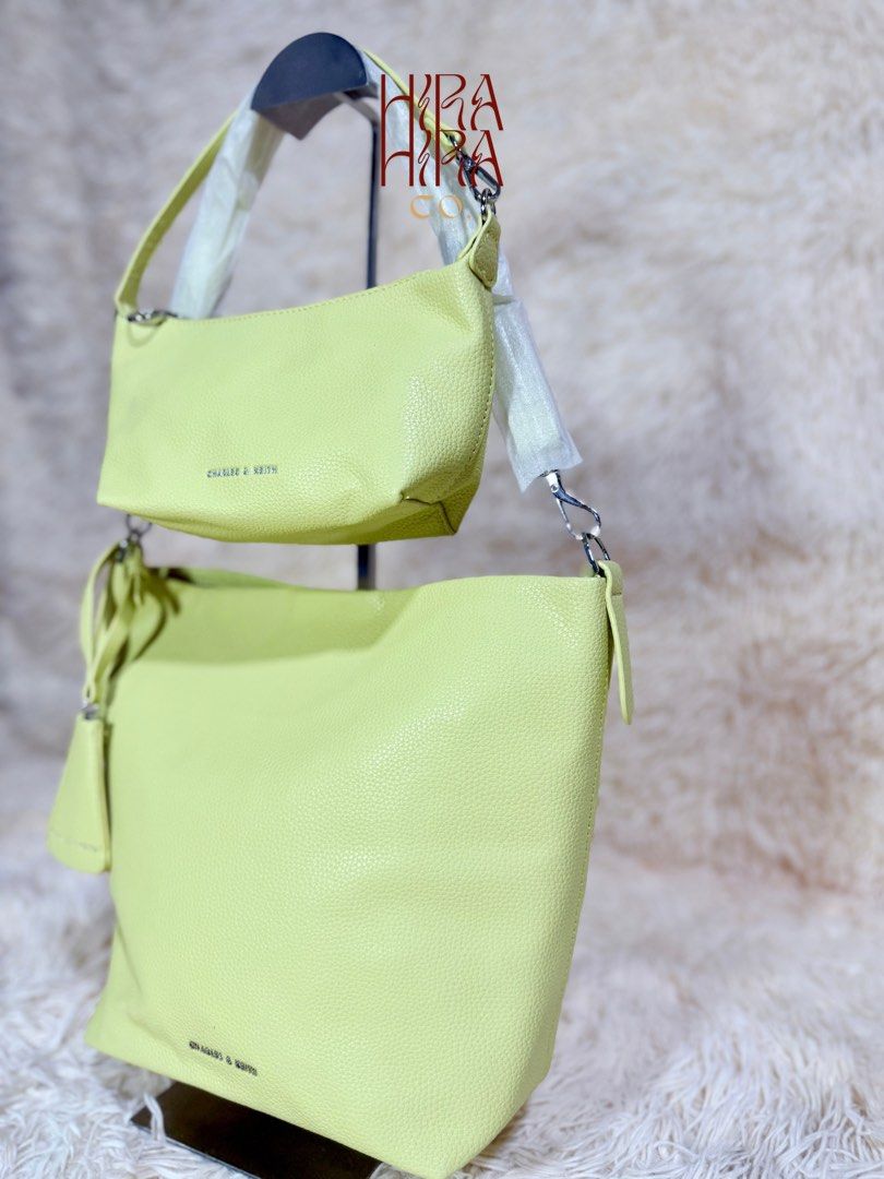 Charles & Keith Lime Green Bucket Bag Set (Category: Shoulder Bags) located in Caloocan City. Submitted by hirahira.co (Listing ID 1467289686, Image 2). Description: - Brand: Charles & Keith - Color: Vibrant lime green with silver-tone hardware - Set includes: 1 large slouchy bucket bag and 1 matching zippered shoulder bag - Material: Textured faux leather with brown interior lining - Condition: Brand new, straps still wrapped in protective plast