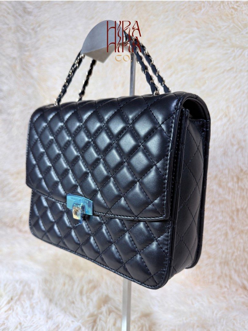 Charles & Keith Quilted Black Handbag with Chain Strap (Category: Luxury Bags & Wallets) located in Caloocan City. Submitted by hirahira.co (Listing ID 1467289351, Image 2). Description: - Brand: Charles & Keith - Style: Black quilted crossbody bag with flap closure - Hardware: Elegant silver and gold twist lock - Straps: Versatile top handle and interwoven chain strap - Interior: Fabric-lined with a zip pocket and gold-foil logo stamp - Conditio