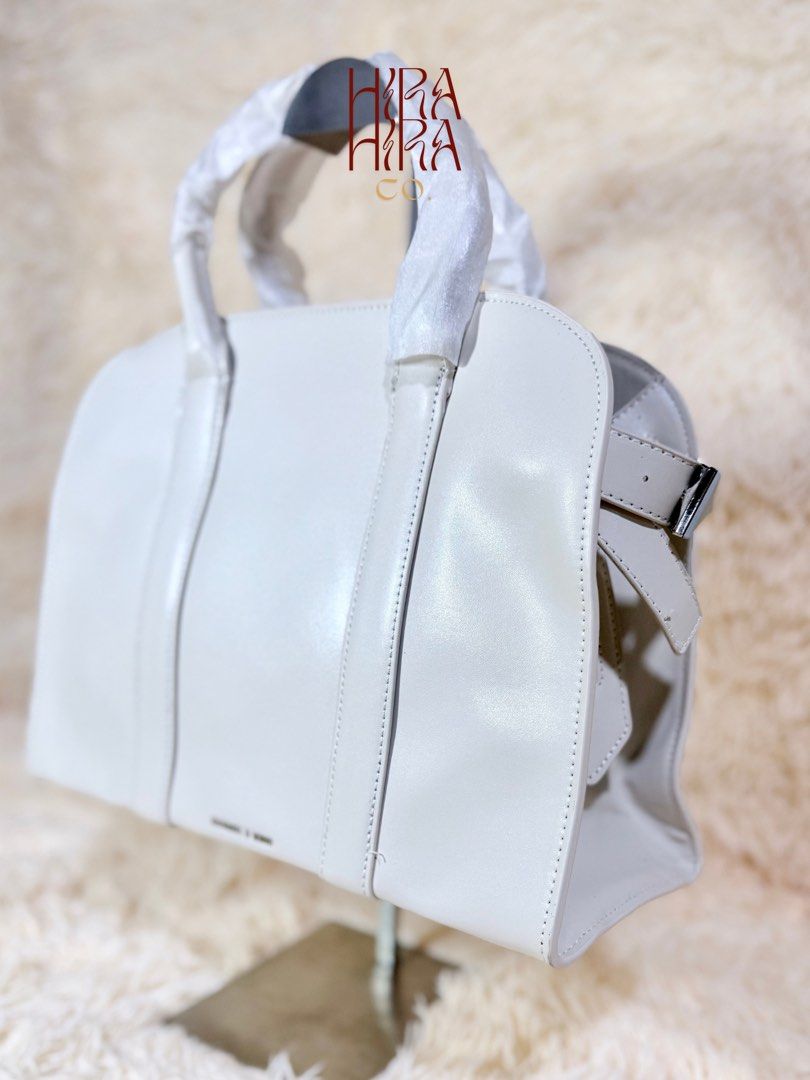 Charles & Keith White Structured Handbag (Category: Luxury Bags & Wallets) located in Caloocan City. Submitted by hirahira.co (Listing ID 1467289099, Image 1). Description: - Brand: Charles & Keith - Color: Clean white - Design: Structured, minimalist, solid color with subtle brand logo - Handles: Dual top handles (still in protective foam packaging) - Closure & Interior: Secure zippered top with a clean lined interior - Strap: Includes an extra 
