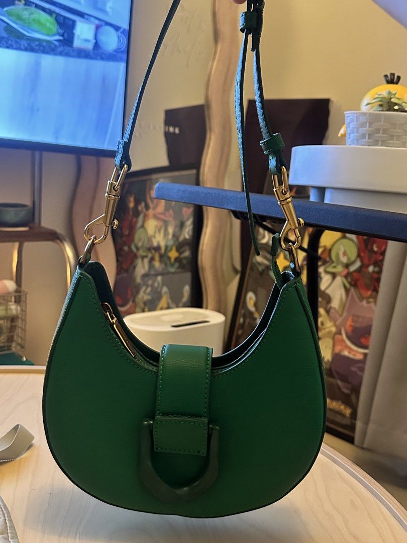 Charles & Keith x Itzy Green Saddle Bag (Category: Shoulder Bags) located in San Pedro. Submitted by sweetcosmics (Listing ID 1467338250, Image 2). Description: - Authentic Charles & Keith x Itzy Collaboration Saddle Bag (Bought from SG) - Color: Vibrant green with chic gold-tone hardware - Design: Curved silhouette, front buckle detail, and embossed Itzy logo on the side gusset - Versatility: Includes an adjustable strap for comfortable wear - I