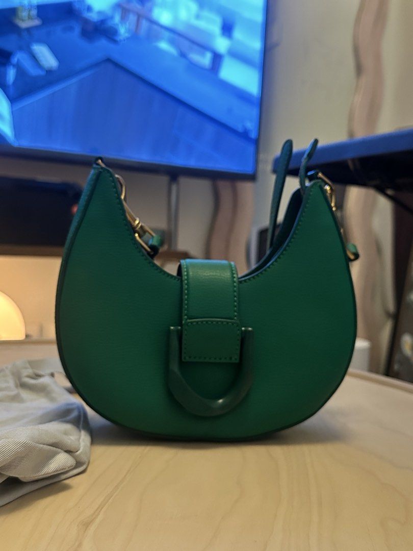 Charles & Keith x Itzy Green Saddle Bag (Category: Shoulder Bags) located in San Pedro. Submitted by sweetcosmics (Listing ID 1467338250, Image 1). Description: - Authentic Charles & Keith x Itzy Collaboration Saddle Bag (Bought from SG) - Color: Vibrant green with chic gold-tone hardware - Design: Curved silhouette, front buckle detail, and embossed Itzy logo on the side gusset - Versatility: Includes an adjustable strap for comfortable wear - I