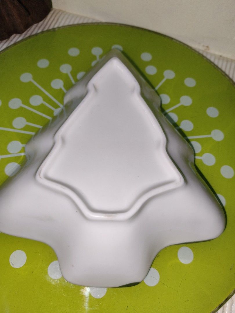 Christmas Tree Shaped Ceramic Dish Festive Serving Tray (Category: Dinnerware & Cutlery) located in Manila. Submitted by reascheyss51406 (Listing ID 1467170767, Image 3). Description: - Christmas tree-shaped ceramic serving dish - Features hand-painted holiday designs including bells, stockings, gift boxes, and mittens - Elegant green trim along the wavy edges - Smooth white glossy finish on both top and bottom - Ideal for serving holiday snacks,