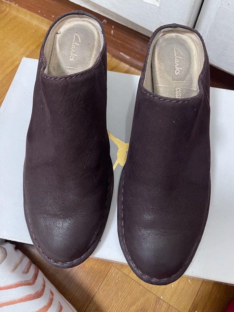 Clarks Cushion Plus Plum Suede Mules Block Heel (Category: Flats & Sandals) located in Taguig. Submitted by 1307maloc (Listing ID 1467214157, Image 1). Description: - Brand: Clarks - Style: Slip-on leather mules with rounded toe - Color: Plum - Heel: Wooden block heel - Comfort: Built-in Cushion technology - Condition: Uppers are clean and scuff-free; soles show light outdoor wear; footbeds have minor dust marks from storage.