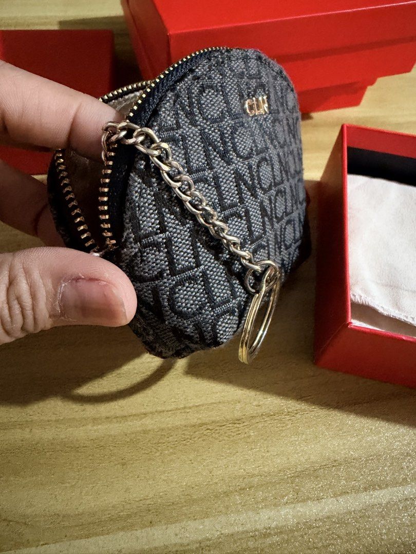 CLN Monogram Coin Purse with Keychain (Category: Purses & Pouches) located in San Juan City. Submitted by thisismeely (Listing ID 1467169079, Image 2). Description: - Brand: CLN - Color: Charcoal grey with stylish monogram print - Hardware: Premium gold-toned hardware - Closure: Secure zip-around design - Interior: Satin lining with monogram print, attached key ring, and chain - Inclusion: Comes with original red CLN branded box.
