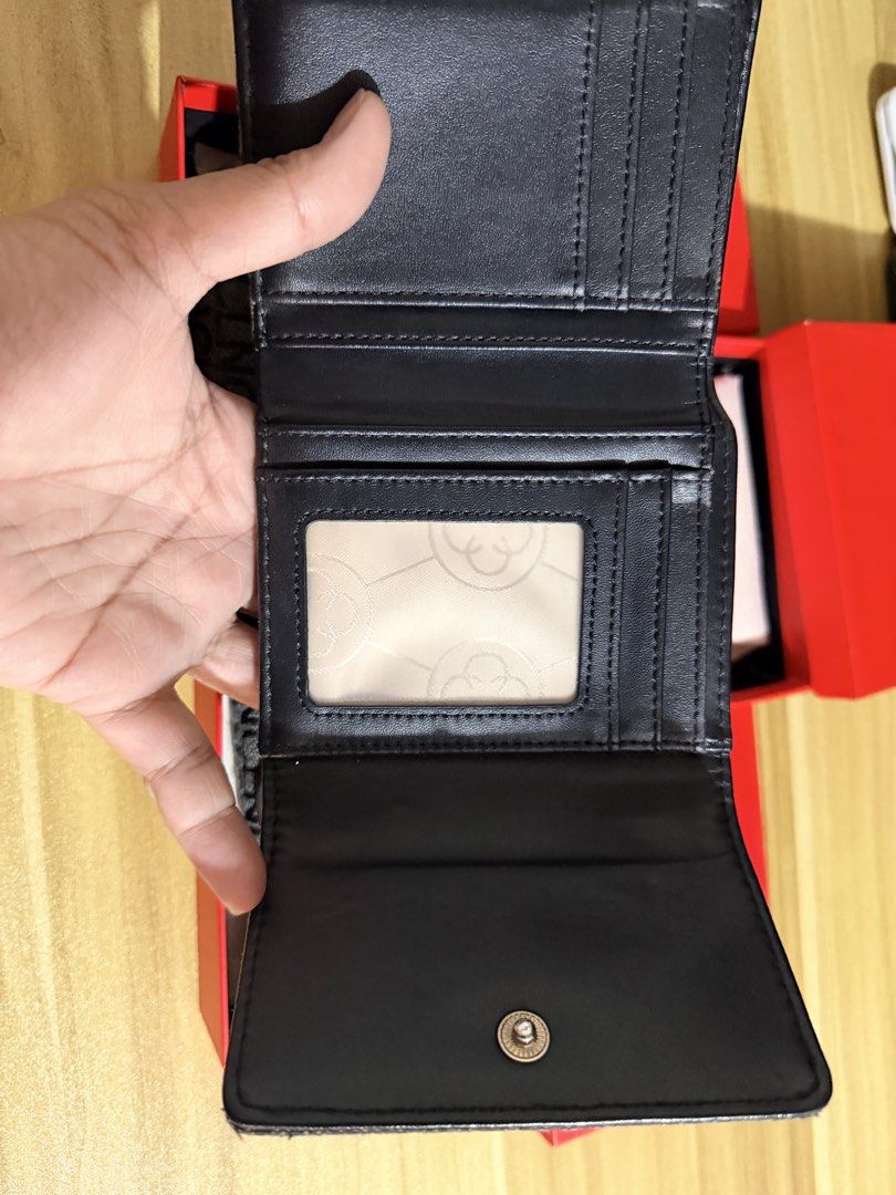 CLN Monogram Tri-fold Wallet with Box (Category: Wallets & Card holders) located in San Juan City. Submitted by thisismeely (Listing ID 1467168882, Image 2). Description: - Brand: CLN - Color: Charcoal grey with all-over monogram print - Hardware: Gold-tone - Interior: Tri-fold design with multiple card slots, clear ID window, and cash compartment - Condition: Brand new, never used - Inclusions: Original branded red presentation box and dust wrap