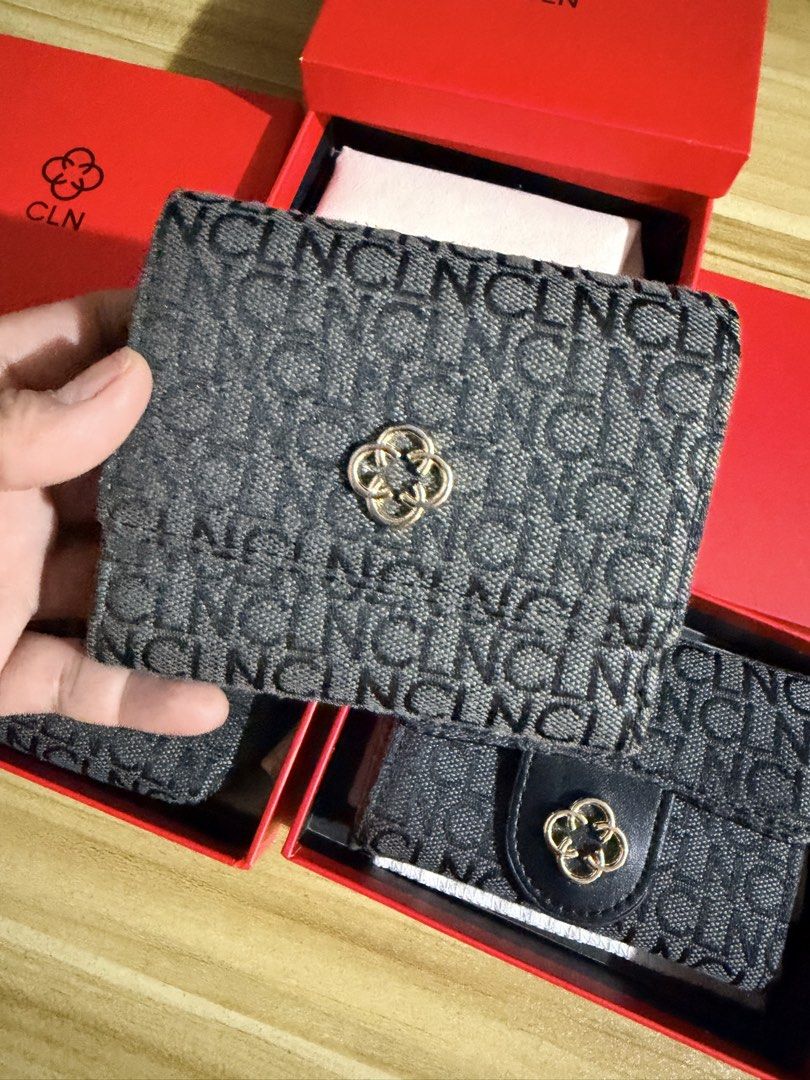 CLN Monogram Tri-fold Wallet with Box (Category: Wallets & Card holders) located in San Juan City. Submitted by thisismeely (Listing ID 1467168882, Image 1). Description: - Brand: CLN - Color: Charcoal grey with all-over monogram print - Hardware: Gold-tone - Interior: Tri-fold design with multiple card slots, clear ID window, and cash compartment - Condition: Brand new, never used - Inclusions: Original branded red presentation box and dust wrap