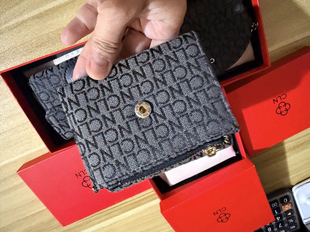 CLN Monogram Tri-fold Wallet with Box (Category: Wallets & Card holders) located in San Juan City. Submitted by thisismeely (Listing ID 1467168882, Image 3). Description: - Brand: CLN - Color: Charcoal grey with all-over monogram print - Hardware: Gold-tone - Interior: Tri-fold design with multiple card slots, clear ID window, and cash compartment - Condition: Brand new, never used - Inclusions: Original branded red presentation box and dust wrap