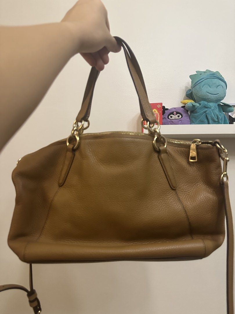 Coach Brown Leather Shoulder Bag (Category: Luxury Bags & Wallets) located in Quezon City. Submitted by sofieegee (Listing ID 1467298259, Image 2). Description: - Brand: Coach - Color: Classic Tan - Material: Premium Leather - Hardware: Elegant gold-tone accents - Closure: Secure zip-top closure - Straps: Double top handles and an adjustable shoulder strap - Exterior: Features Coach logo and matching leather hangtag - Interior: Roomy and structur