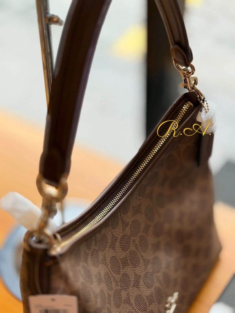 Coach Brown Signature Canvas Shoulder Bag (Category: Luxury Bags & Wallets) located in Manila. Submitted by rhona30antiquera (Listing ID 1467229712, Image 2). Description: - Authentic Coach brown signature canvas shoulder bag - Elegant gold-tone hardware with dark brown trim - Secure zip-top closure - Includes a detachable leather strap for versatile cross-body wear - Signature hangtag attached.