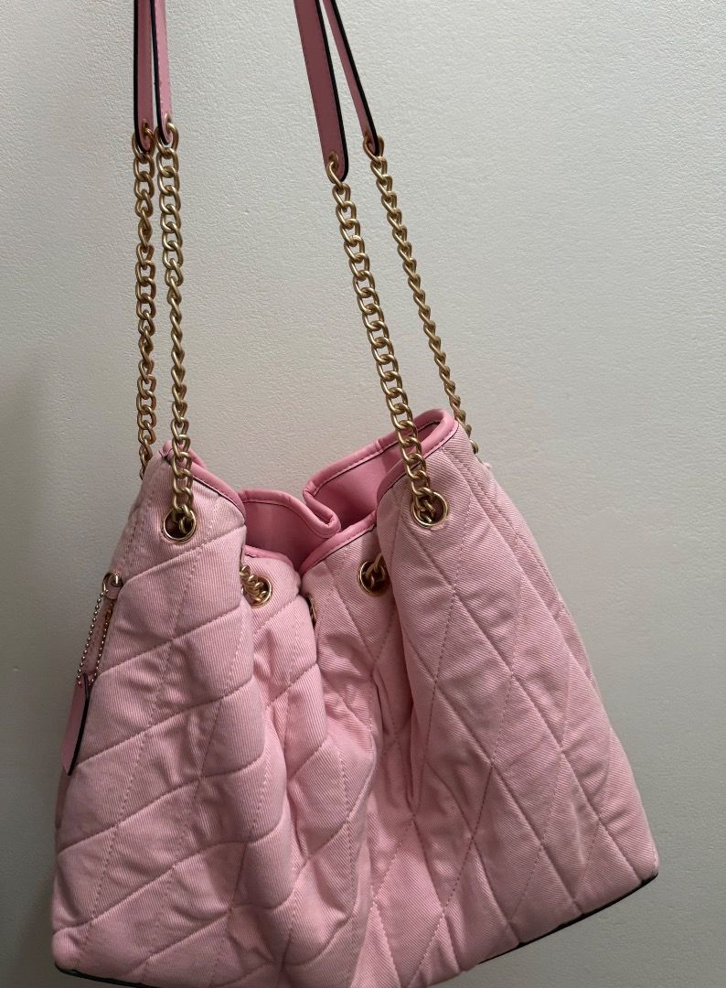 Coach Evelyn Denim Pink (Category: Luxury Bags & Wallets) located in Valenzuela. Submitted by raquesells (Listing ID 1467339422, Image 2). Description: - Brand: Coach - Style: Quilted shoulder bag with drawstring closure - Color: Soft pink with luxurious gold-tone hardware and chain straps - Interior: Pink lining featuring the classic leather Coach creed patch - Capacity: Comfortably fits your daily essentials - Condition: Good pre-loved conditio