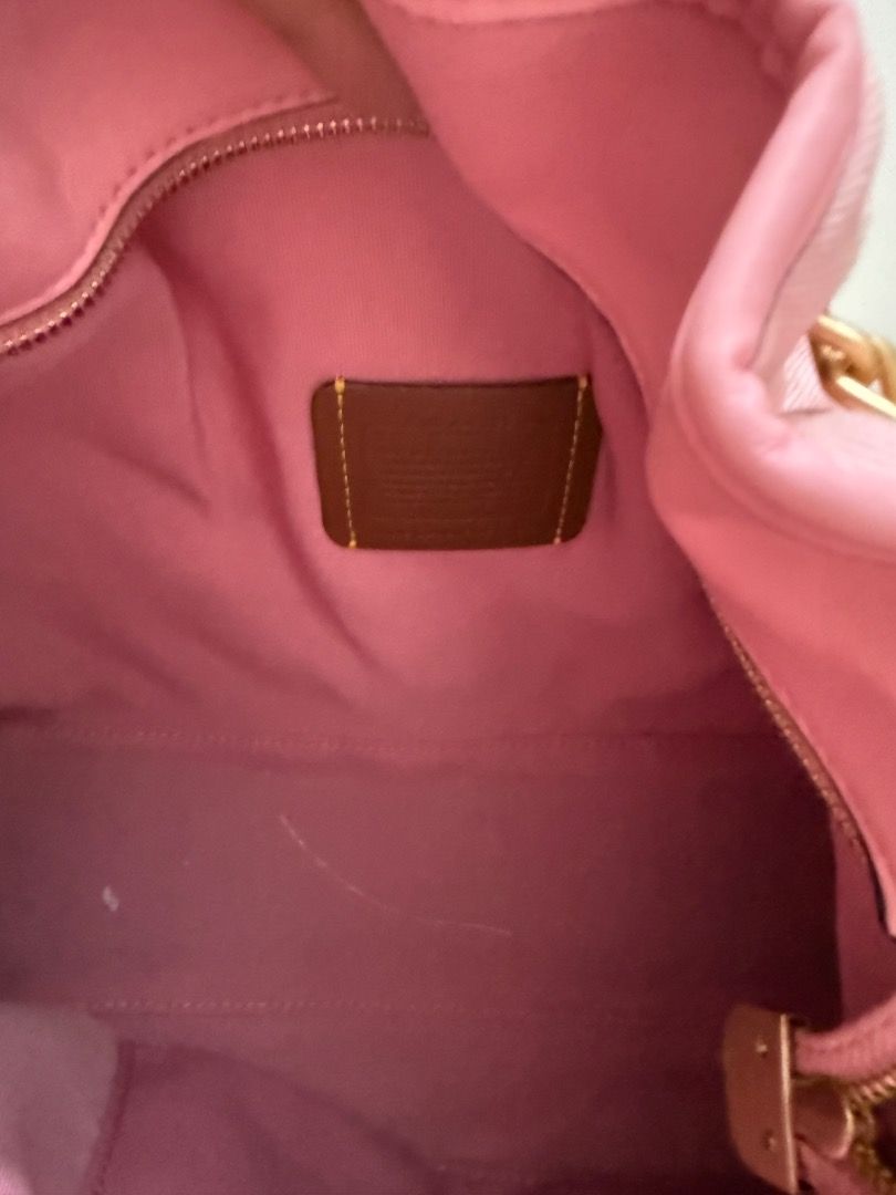 Coach Evelyn Denim Pink (Category: Luxury Bags & Wallets) located in Valenzuela. Submitted by raquesells (Listing ID 1467339422, Image 3). Description: - Brand: Coach - Style: Quilted shoulder bag with drawstring closure - Color: Soft pink with luxurious gold-tone hardware and chain straps - Interior: Pink lining featuring the classic leather Coach creed patch - Capacity: Comfortably fits your daily essentials - Condition: Good pre-loved conditio