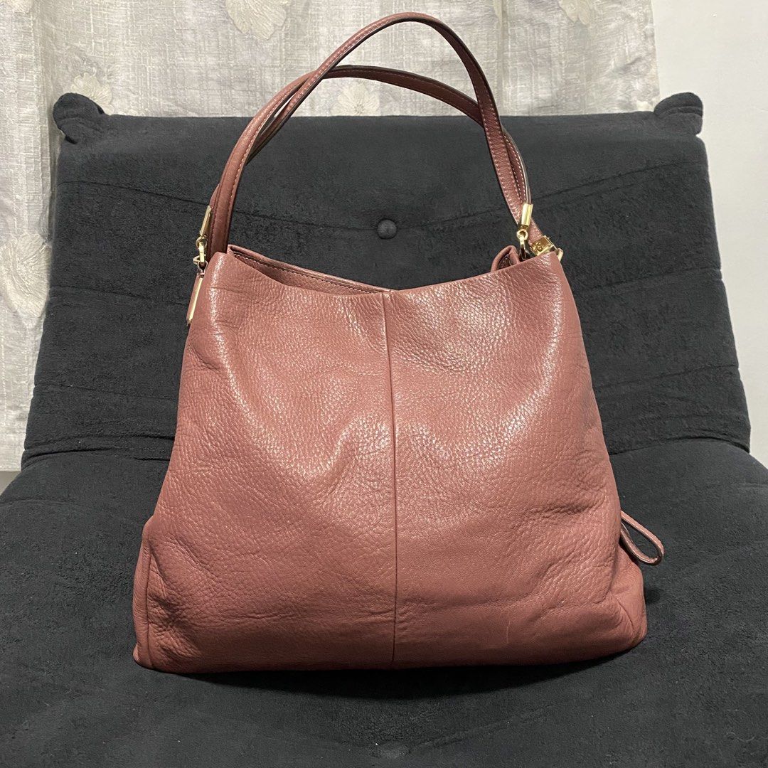 Coach Pink Leather Shoulder Bag (Category: Luxury Bags & Wallets) located in Baliuag. Submitted by thriftpuff (Listing ID 1467320727, Image 1). Description: - Authentic Coach shoulder bag in gorgeous pink pebbled leather - Elegant gold-tone hardware and gold foil Coach logo stamp - Dual shoulder straps with stylish rectangular connectors - Organized interior with divided compartments and a central zipped section - Additional interior slip pockets