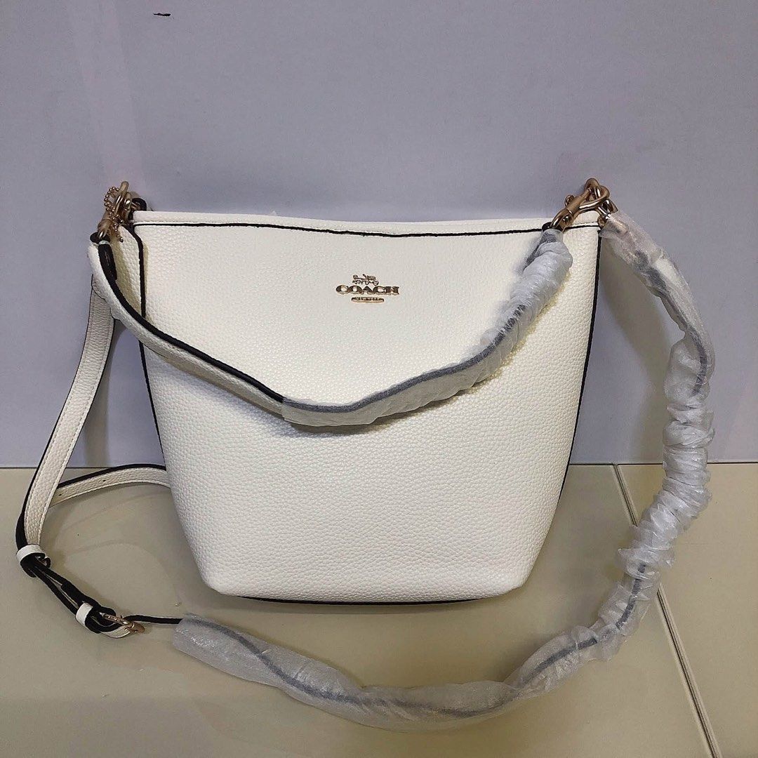 Coach White Bucket Bag Crossbody (Category: Cross-body Bags) located in Manila. Submitted by clairetot (Listing ID 1467203310, Image 2). Description: Coach bucket bag in solid white pebble leather or signature monogram canvas. Features gold hardware, a top handle, and a detachable long strap. Brand new with protective foam, secure closures, and a clean interior..