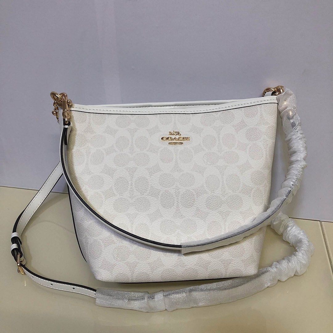 Coach White Bucket Bag Crossbody (Category: Cross-body Bags) located in Manila. Submitted by clairetot (Listing ID 1467203310, Image 3). Description: Coach bucket bag in solid white pebble leather or signature monogram canvas. Features gold hardware, a top handle, and a detachable long strap. Brand new with protective foam, secure closures, and a clean interior..