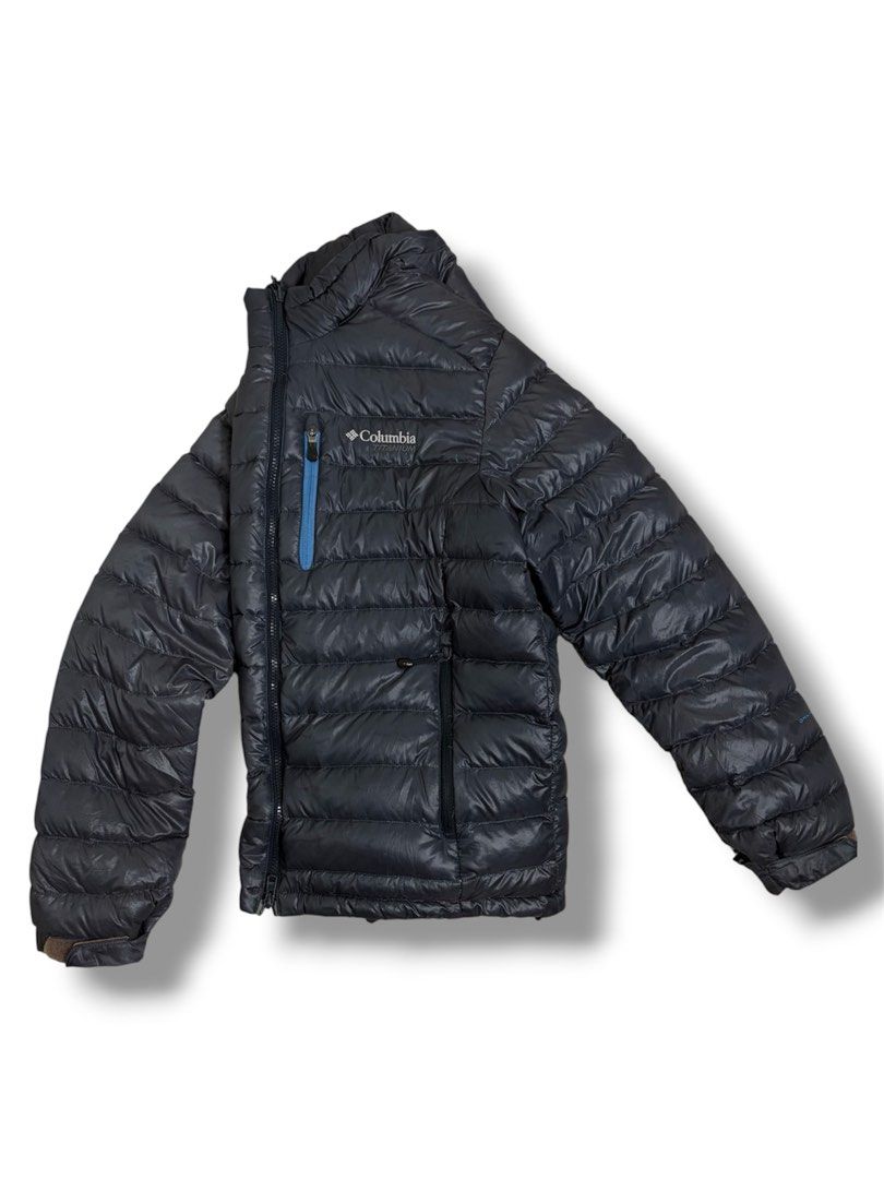 COLUMBIA OMNI-HEAT DOWN PUFFER JACKET (Category: Coats, Jackets and Outerwear) located in Cavite. Submitted by frankiemnla (Listing ID 1467324013, Image 1). Description: L- 27.5 W- 23 Size- M to L Excellent condition • Design: Lightweight horizontal puffer baffling with a full-length zipper. • Distinct Details: Features a signature vertical zippered chest pocket highlighted by a contrasting blue accent outline, matching the dark charcoal/navy blu