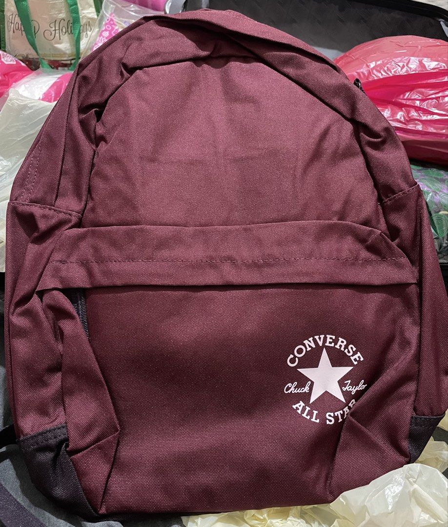 Converse Chuck Taylor All Star Maroon Backpack (Category: Backpacks) located in Quezon City. Submitted by stuffsrus (Listing ID 1467189358, Image 1). Description: Maroon backpack from Converse. Chuck Taylor All Star logo printed on the front pocket in white. Simple main compartment and front zip pouch. Durable fabric construction with black corner reinforcements at the base. Standard shoulder straps attached. Clean look, ready for daily use to sc