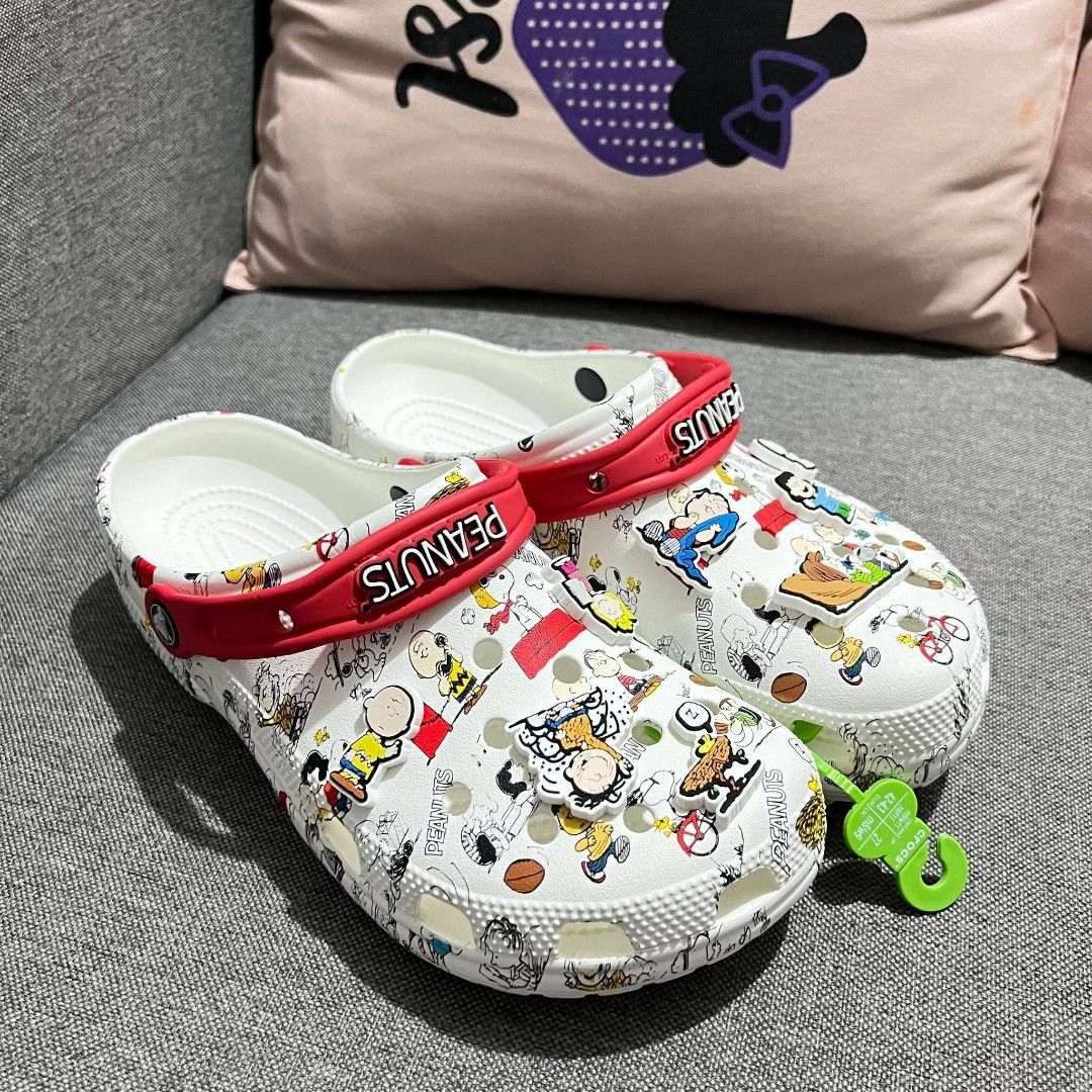 Crocs Peanuts Snoopy Charlie Brown White Clogs (Category: Slippers & Slides) located in Manila. Submitted by onlineshopmate (Listing ID 1467177656, Image 1). Description: - Brand new with green tag attached - Authentic Crocs covered in classic Peanuts comic strip prints (Snoopy, Charlie Brown & gang) - Features a contrasting red heel strap with raised 'PEANUTS' text in white - Comes with multiple character Jibbitz charms already attached - Super 