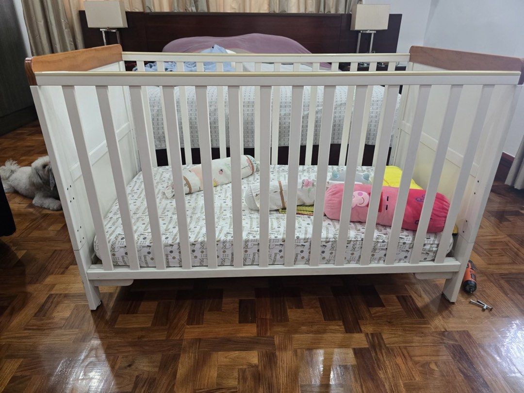 Cuddle Bug Fontana 2-in-1 Crib (White) (Category: Cots & Cribs) located in Manila. Submitted by shopbucks (Listing ID 1467348039, Image 1). Description: - Style: White wooden baby cot with stylish natural wood top rails. - Material: Pine wood - Dimensions: Approx. 136cm (L) x 76cm (W) x 86cm (H) - 3 mattress asjustment heights (crib) - Can be converted from crib to toddler bed - Condition: Sturdy with signs of years of usage. But still in very go
