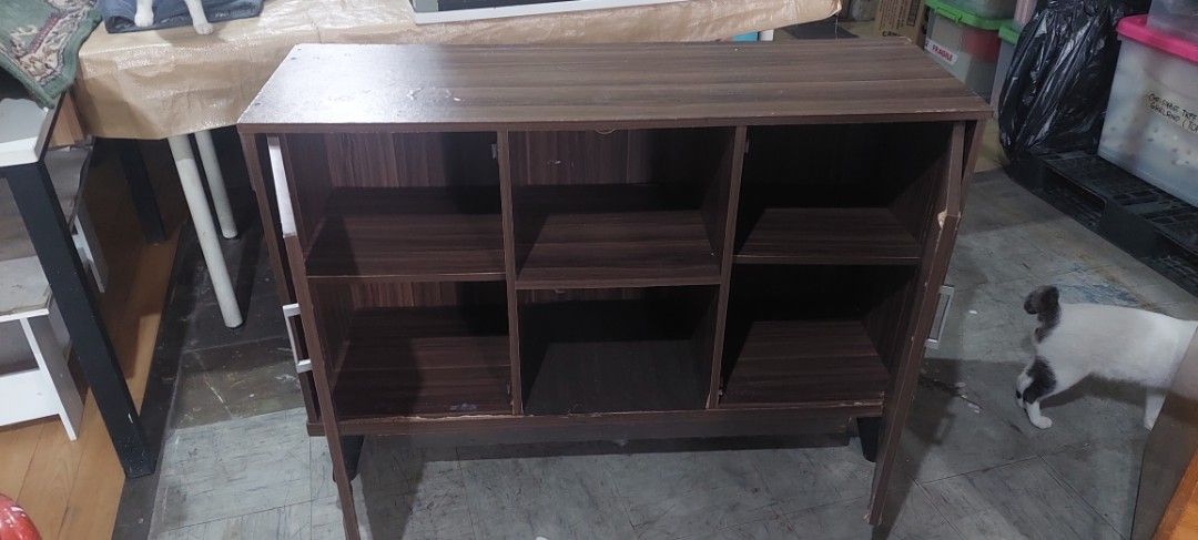 Dark Wood Storage Cabinet (Category: Shelves, Cabinets & Racks) located in Manila. Submitted by mcangwong80885 (Listing ID 1467226076, Image 3). Description: - Style: Dark wood grain finish with modern angled legs - Storage: Two side cabinets with metal handles and two open middle shelves - Ideal Use: Great storage solution for the living room or entryway.