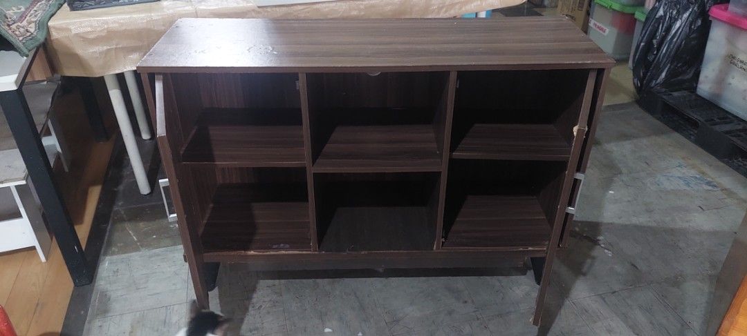 Dark Wood Storage Cabinet (Category: Shelves, Cabinets & Racks) located in Manila. Submitted by mcangwong80885 (Listing ID 1467226076, Image 2). Description: - Style: Dark wood grain finish with modern angled legs - Storage: Two side cabinets with metal handles and two open middle shelves - Ideal Use: Great storage solution for the living room or entryway.
