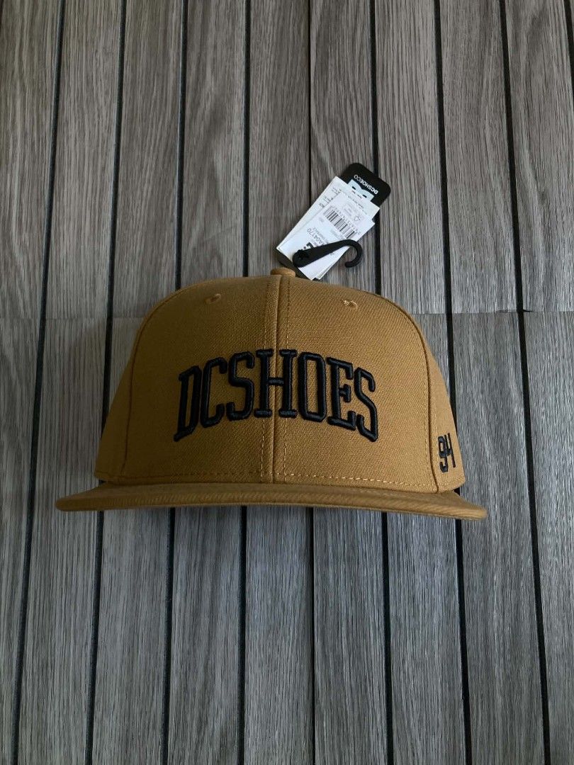 DC Shoes Adyha04170 Semi-Pro Snapback Cap Wheat Brown (Category: Caps & Hats) located in Trece Martires City. Submitted by djaothriftshop (Listing ID 1467293214, Image 1). Description: - Brand: DC Shoes - Style: Snapback cap with structured crown and flat brim - Color: Wheat brown - Details: Embroidered front logo and '94' embroidery on the side - Closure: Adjustable plastic snapback - Condition: Brand new with tags attached - Size: One size fits