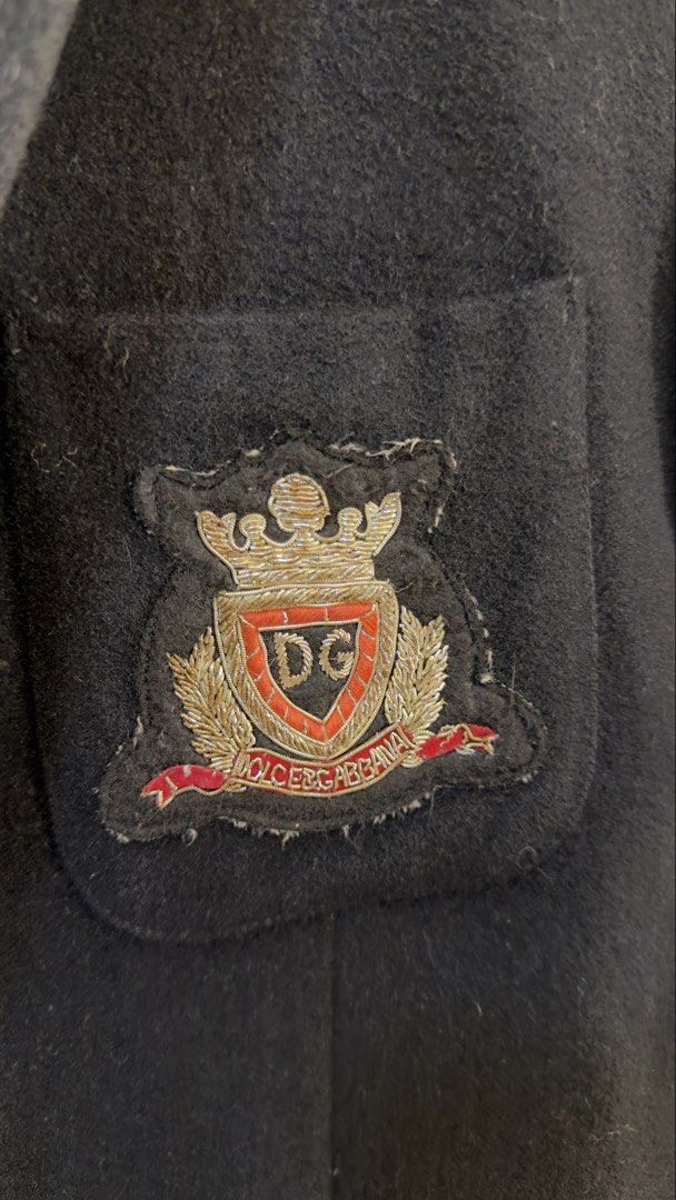 D&G Dolce & Gabbana Crest Patch Slim Blazer Black (Category: Coats, Jackets and Outerwear) located in Paranaque City. Submitted by preluxeshop_ph (Listing ID 1467296480, Image 3). Description: D&G Dolce & Gabbana Crest Patch Slim Blazer Black - Features a stylish embroidered crest patch on the chest pocket - Elegant patterned inner lining with structured shoulders and lapel collar - Two-button front closure for a sharp, tailored silhouette - Vers
